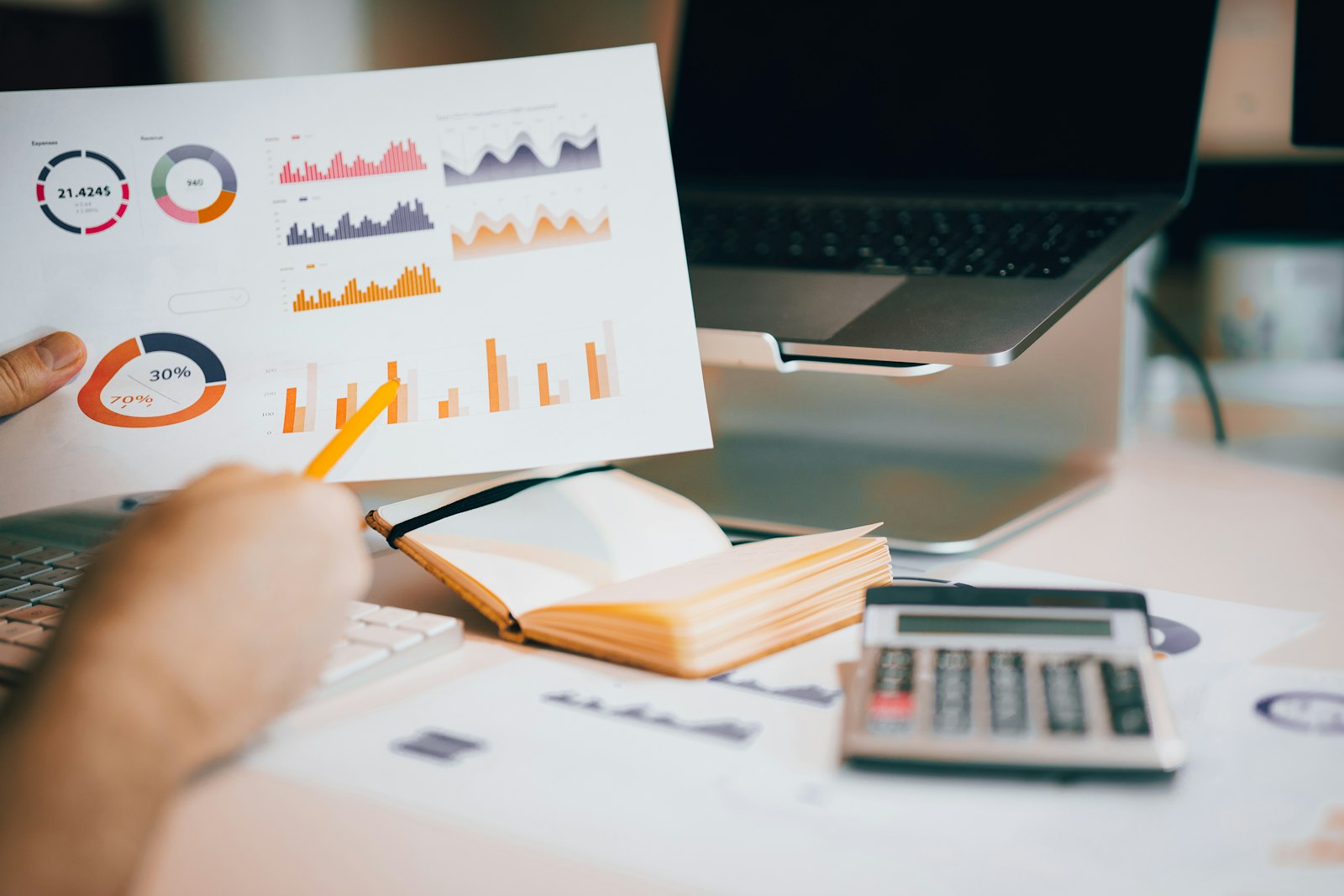 Relatório financeiro com gráficos e calculadora sobre a mesa